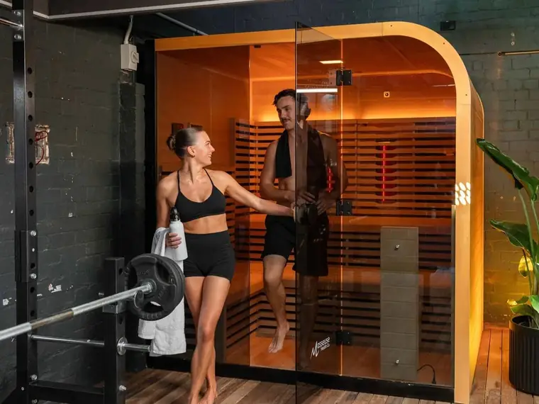 Members beside the Berry Fitness infrared sauna in the gym